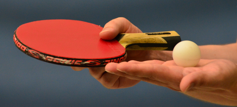 Table tennis racket and ball in hands
