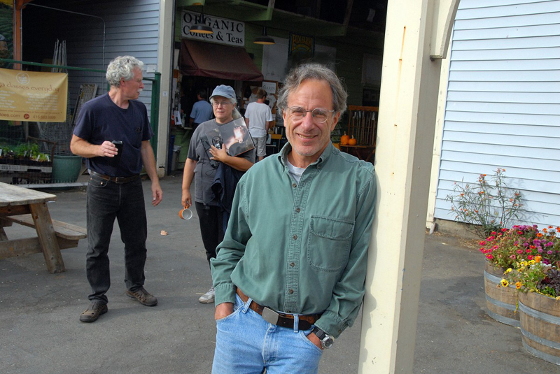 Writer Jonathan Rowe standing, leaning against a post.