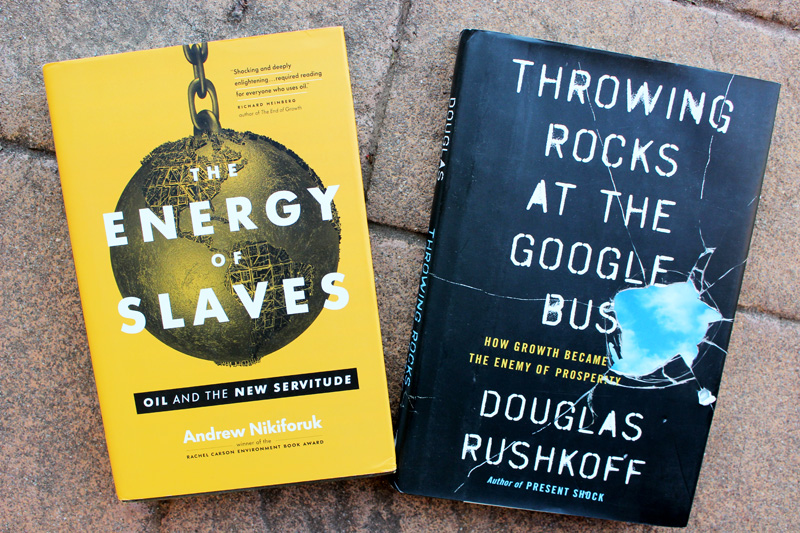 Book covers: "The Energy of Slaves" by Andrew Nikiforuk, and "Throwing Rocks at the Google Bus" by Douglas Rushkoff