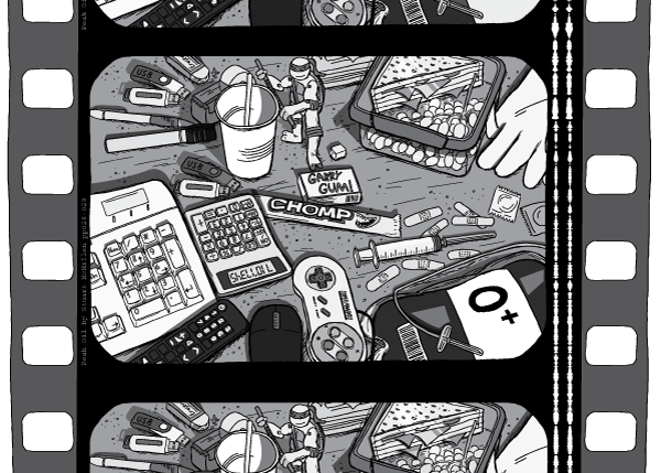 Film strip showing a messy desk of plastic objects. Film perforations are visible down the edges of the film.