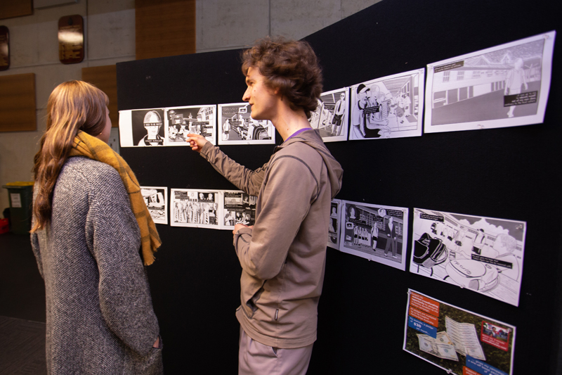 Photo of Stuart McMillen showing his artwork at an event