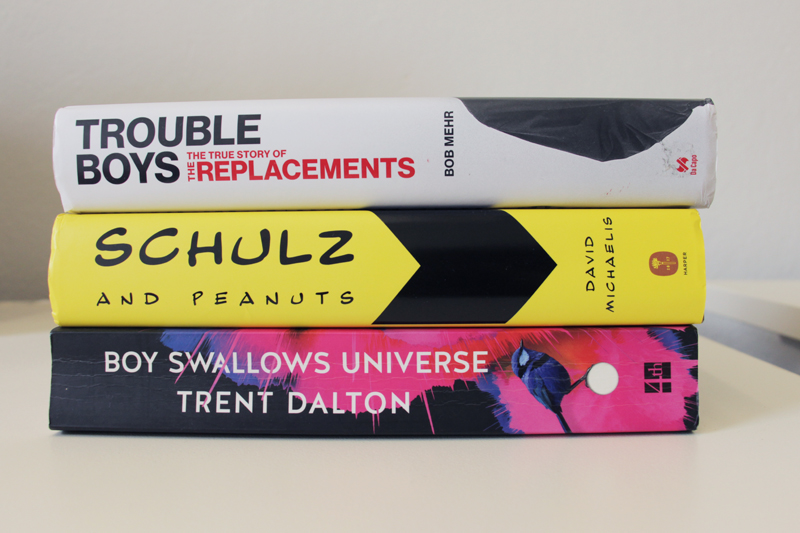 Spines of books: "Trouble Boys" by Bob Mehr, "Schulz and Peanuts" by David Michaelis, and "Boy Swallows Universe" by Trent Dalton