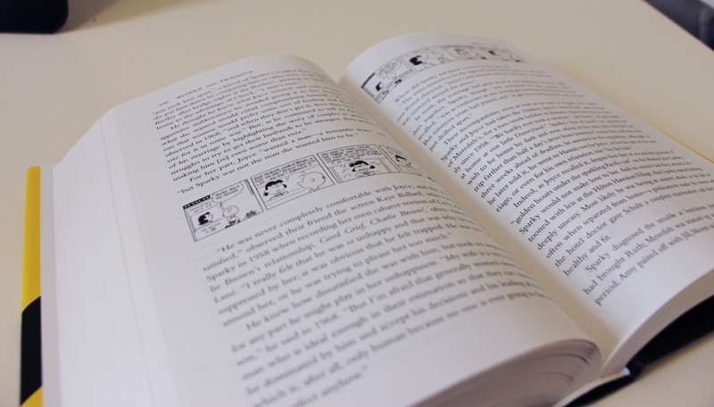Detail of pages of book "Schulz and Peanuts" by David Michaelis showing Peanuts cartoons on page