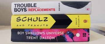 Spines of books: "Trouble Boys" by Bob Mehr, "Schulz and Peanuts" by David Michaelis, and "Boy Swallows Universe" by Trent Dalton