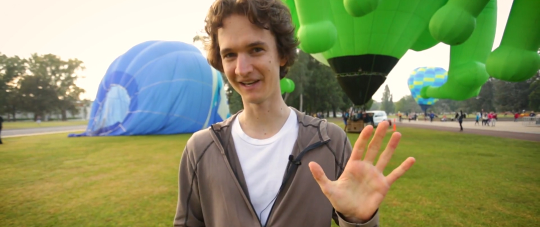 Stuart McMillen speaking in front of hot air balloons